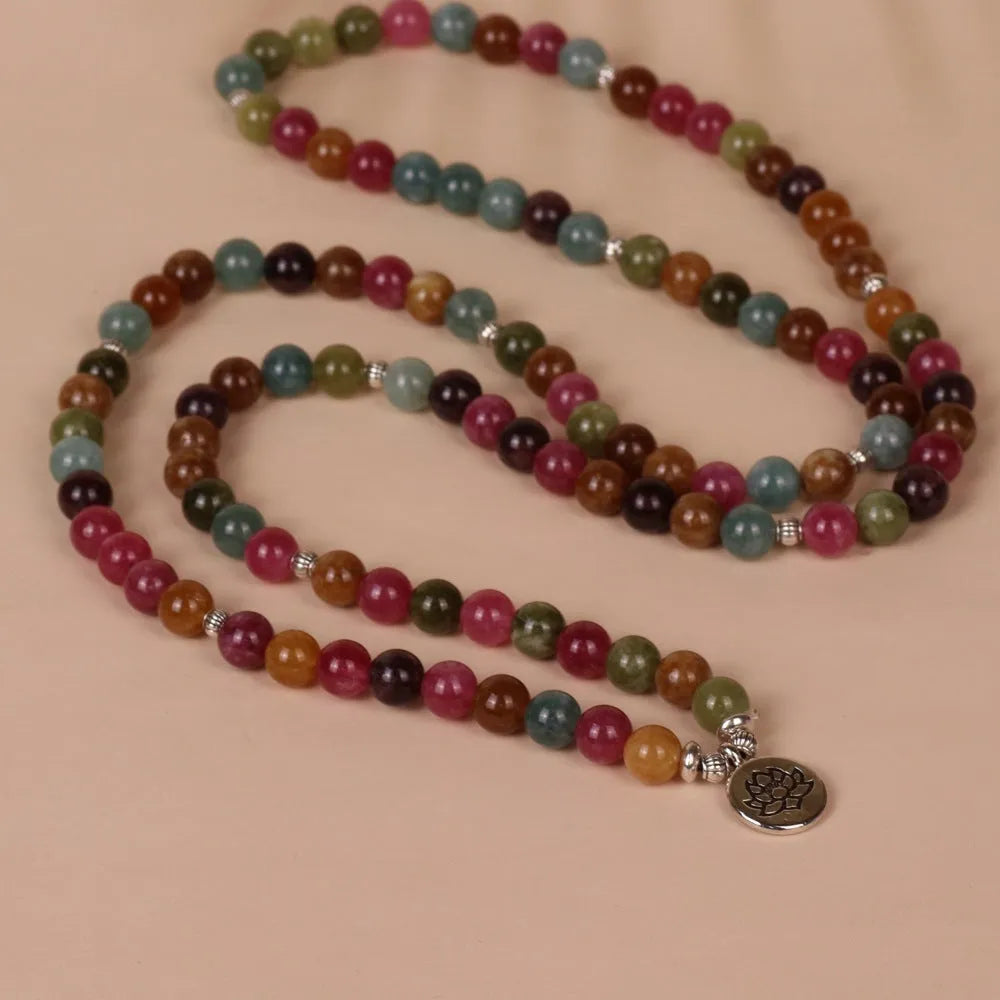 108 bead multi-strand bracelet with natural tourmaline stones and alloy clasp on a wrist.