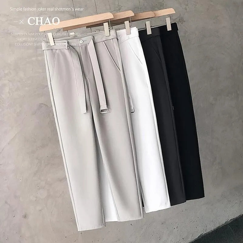 Boys slim straight wool trousers in tapered fit, shown in black, on a hanger.