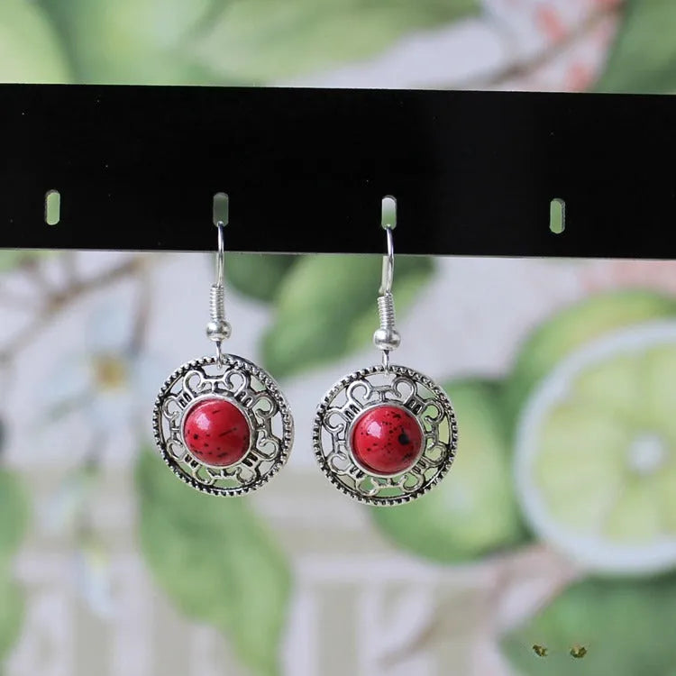Handmade Miao silver geometric flower disk earrings with turquoise and auspicious cloud patterns in red, blue, black.