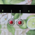 Handmade Miao silver geometric flower disk earrings with turquoise and auspicious cloud patterns in red, blue, black.