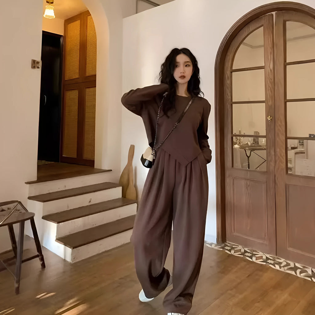 Women's loose brown polyester sports suit with top and trousers on a hanger.