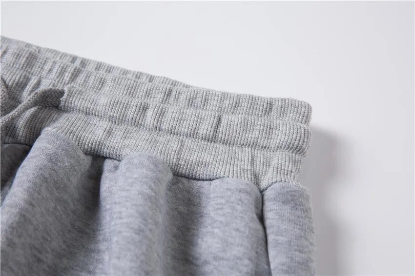 Men's loose-fit casual sweater suit with letter print in black, showing top and matching pants.
