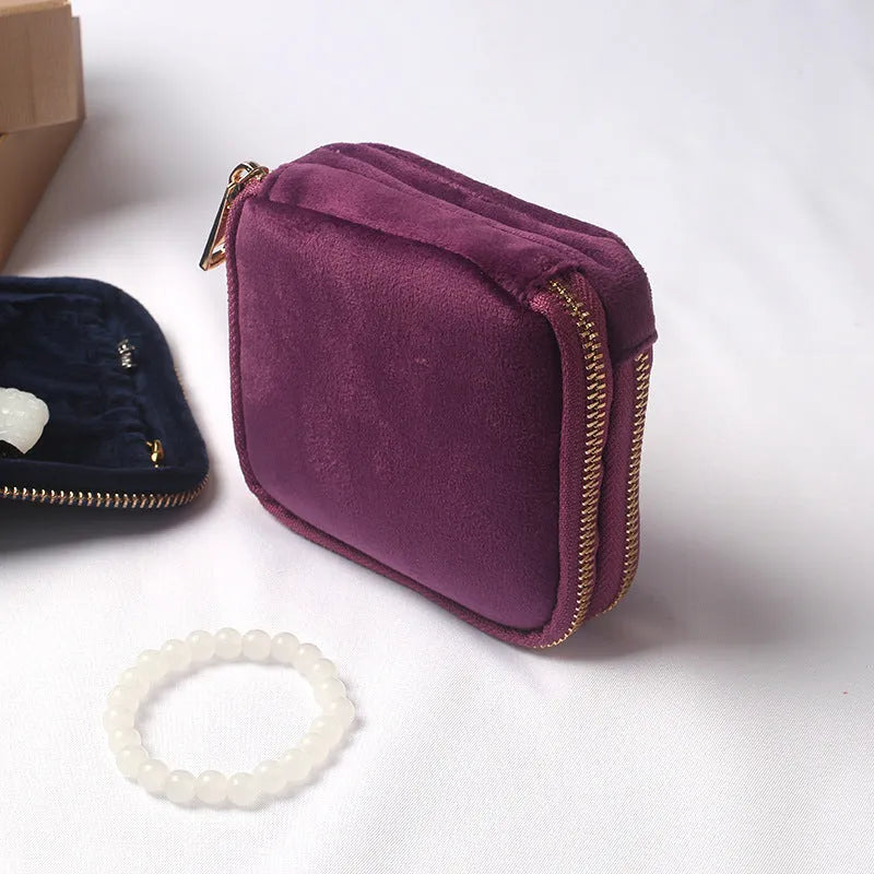 Blue PU zippered jewellery storage bag in handbag shape, 11x11x3.5cm, on a travel background