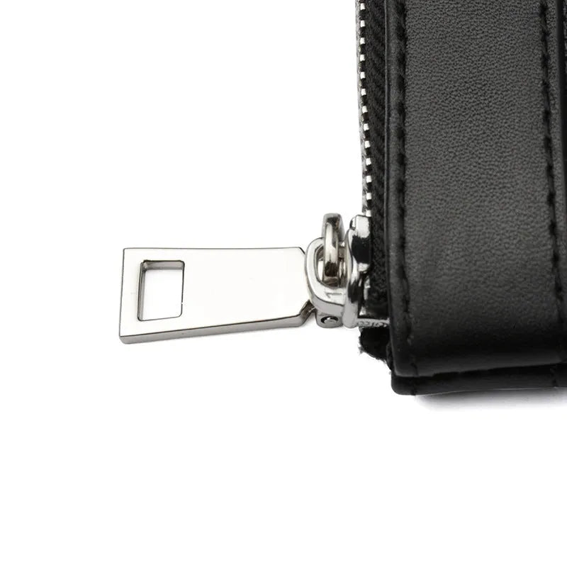 Black men's leather clutch wallet showing plaid lining, closed view