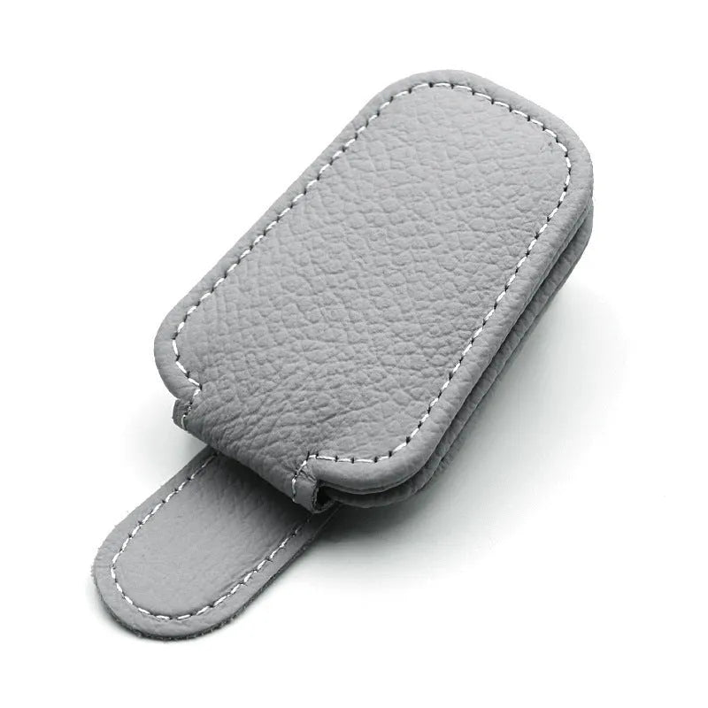 PU leather car sunglasses clip holder mounted on a grey sun visor.