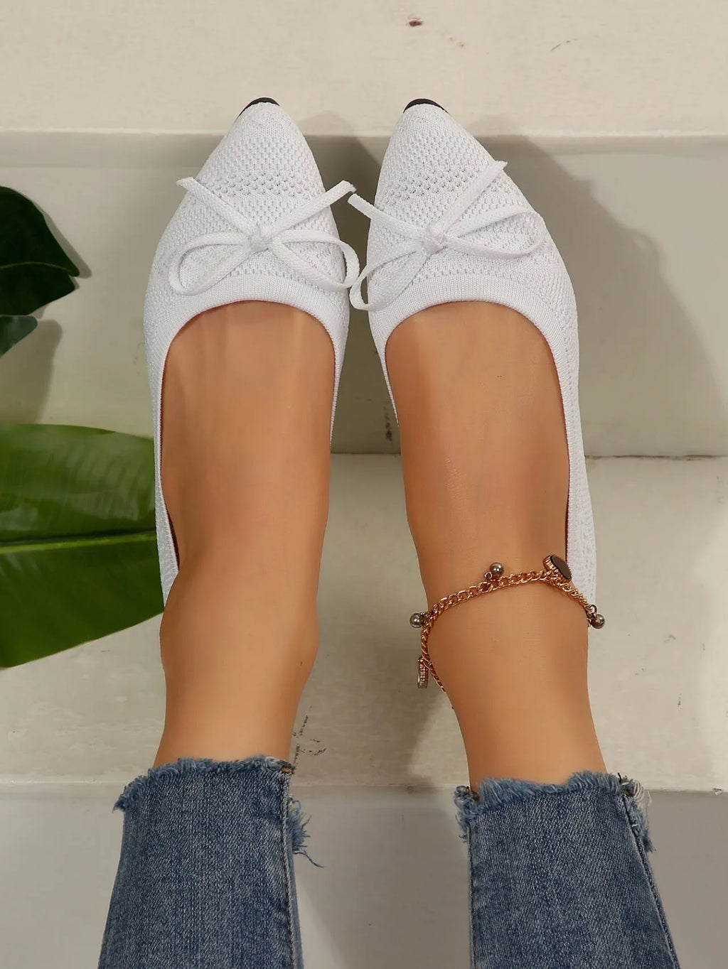 Women's blue knitted loafers with a bow detail and pointed toe on a flat rubber sole.
