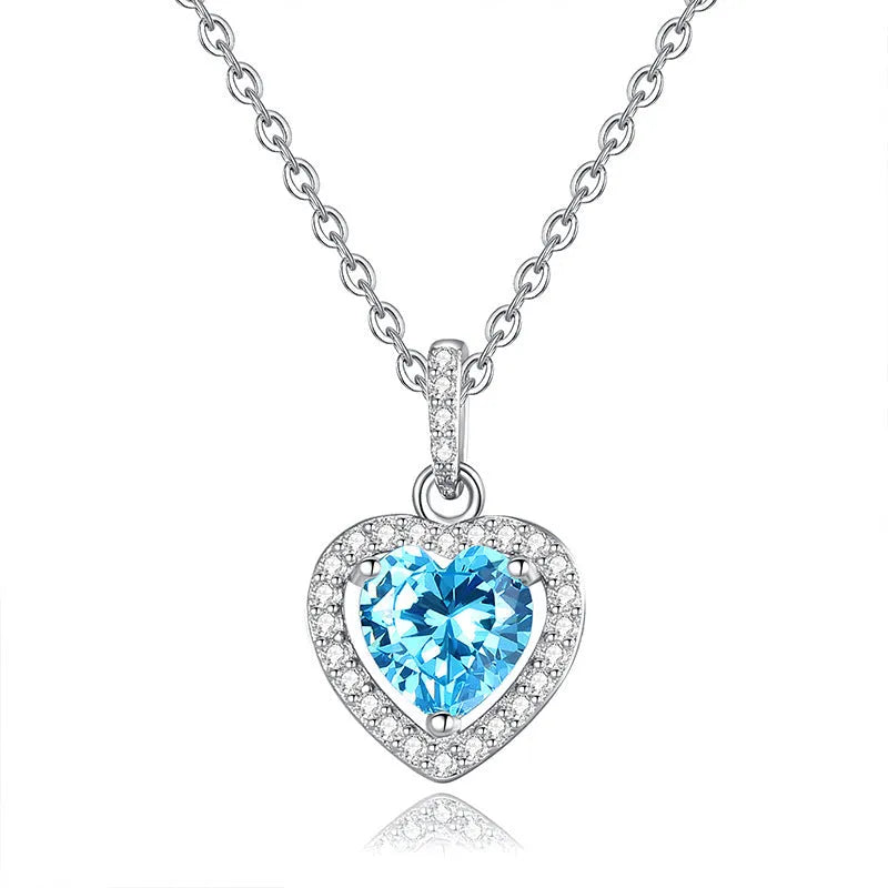 Women's sterling silver heart necklace with a natural gemstone on an adjustable cross chain.