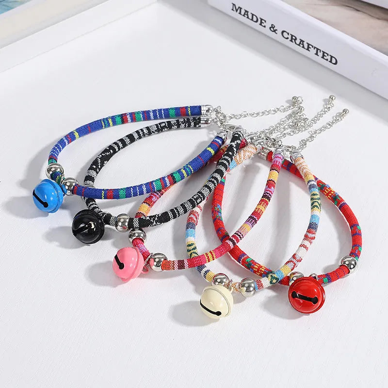 Coloured ethnic style pet collar with a metal bell on a cat or small dog