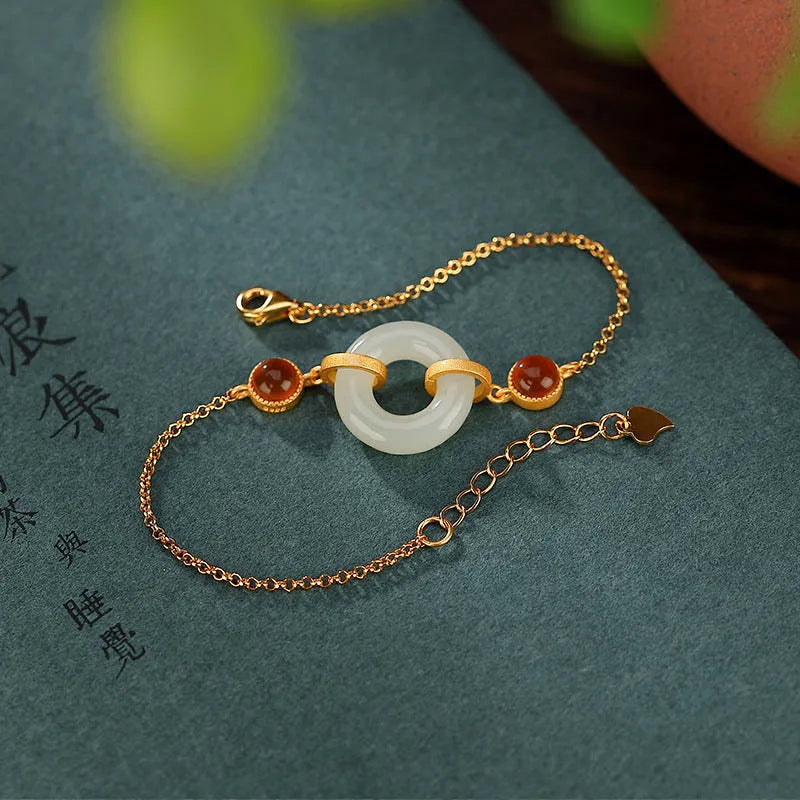 Gold plated S925 sterling silver bracelet with an inlaid natural Hetian jade peace buckle charm.