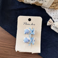 One pair of children's cloth hair clips with bow and flower detailing, shown in a choice of five styles and two clip sizes.