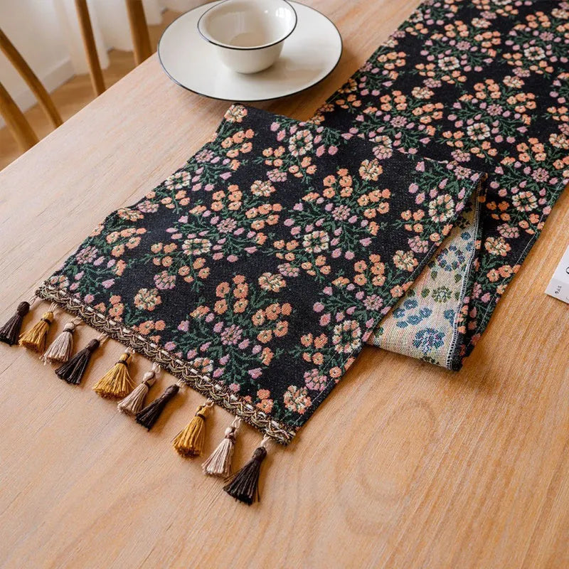 Rhyme Nordic striped jacquard table runner with tassel fringe in dark blue on a wooden table.