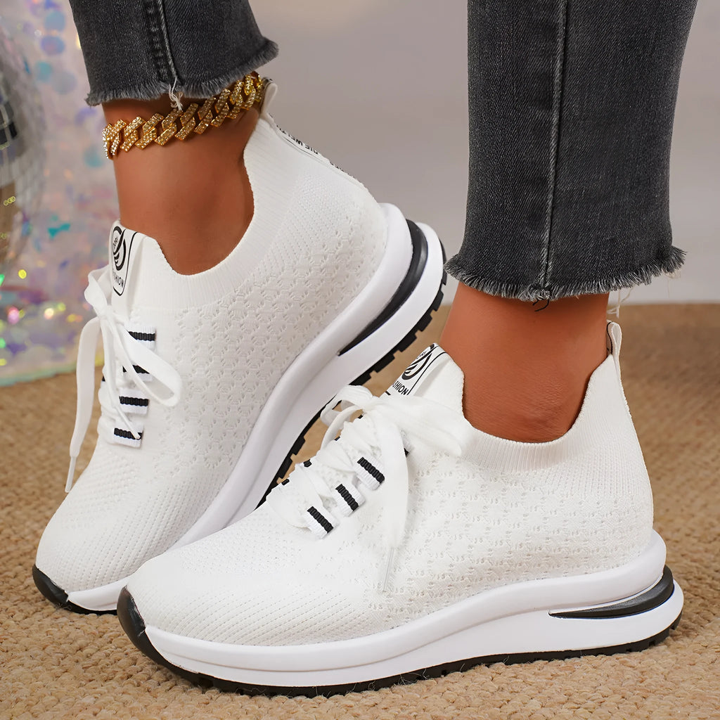Women's black and white lace-up mesh platform sneakers with a flat rubber sole on a neutral background.