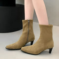 Brown square toe kitten heel mid-calf boots with side zipper on a wooden floor.