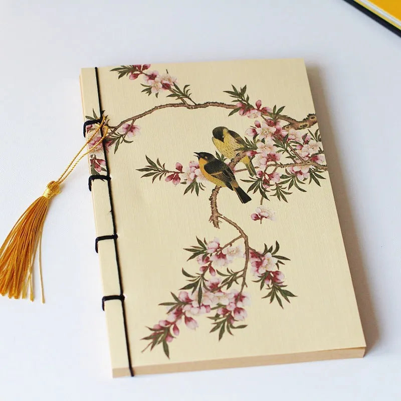 A5 antique wire-bound notebook with a retro famous painting cover on white cowhide, shown open on Kraft paper pages.