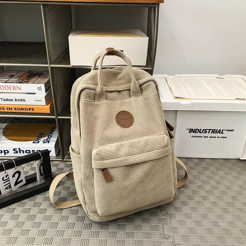 Retro unisex corduroy backpack in solid colour with breathable fabric, side view.