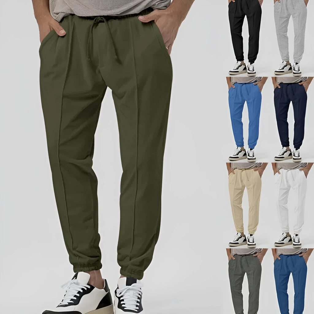 Man wearing grey straight-leg casual track sweatpants with an elasticated waist and micro-elastic fabric.