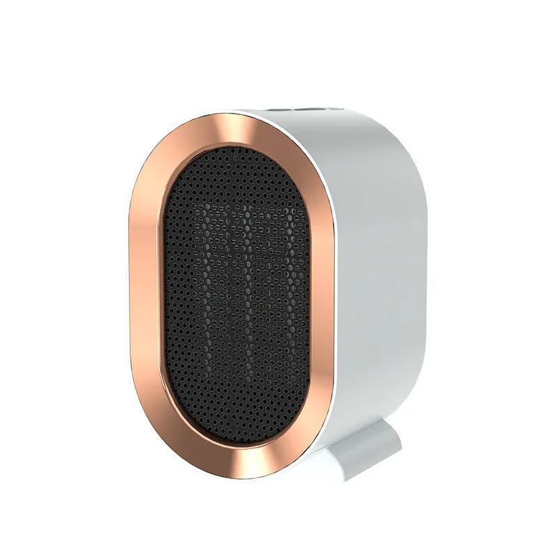 A compact black desktop ceramic fan heater with a mechanical control knob on a wooden desk.
