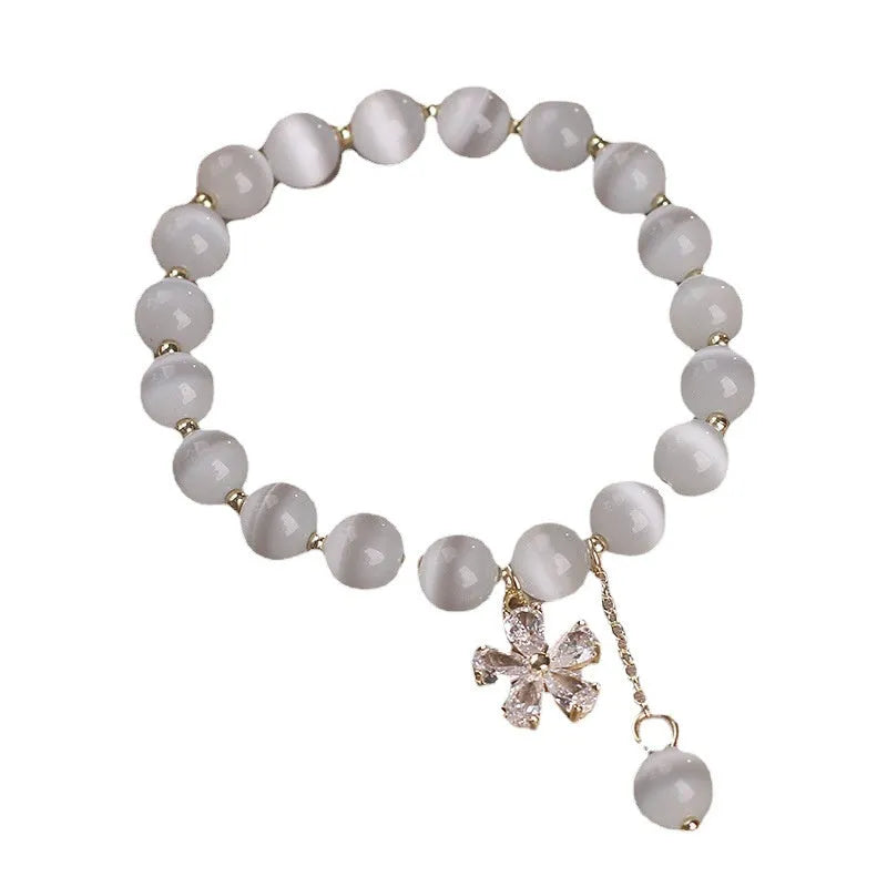 Single loop white cat's eye crystal bracelet with flower tassels and a morganite safety buckle pendant.