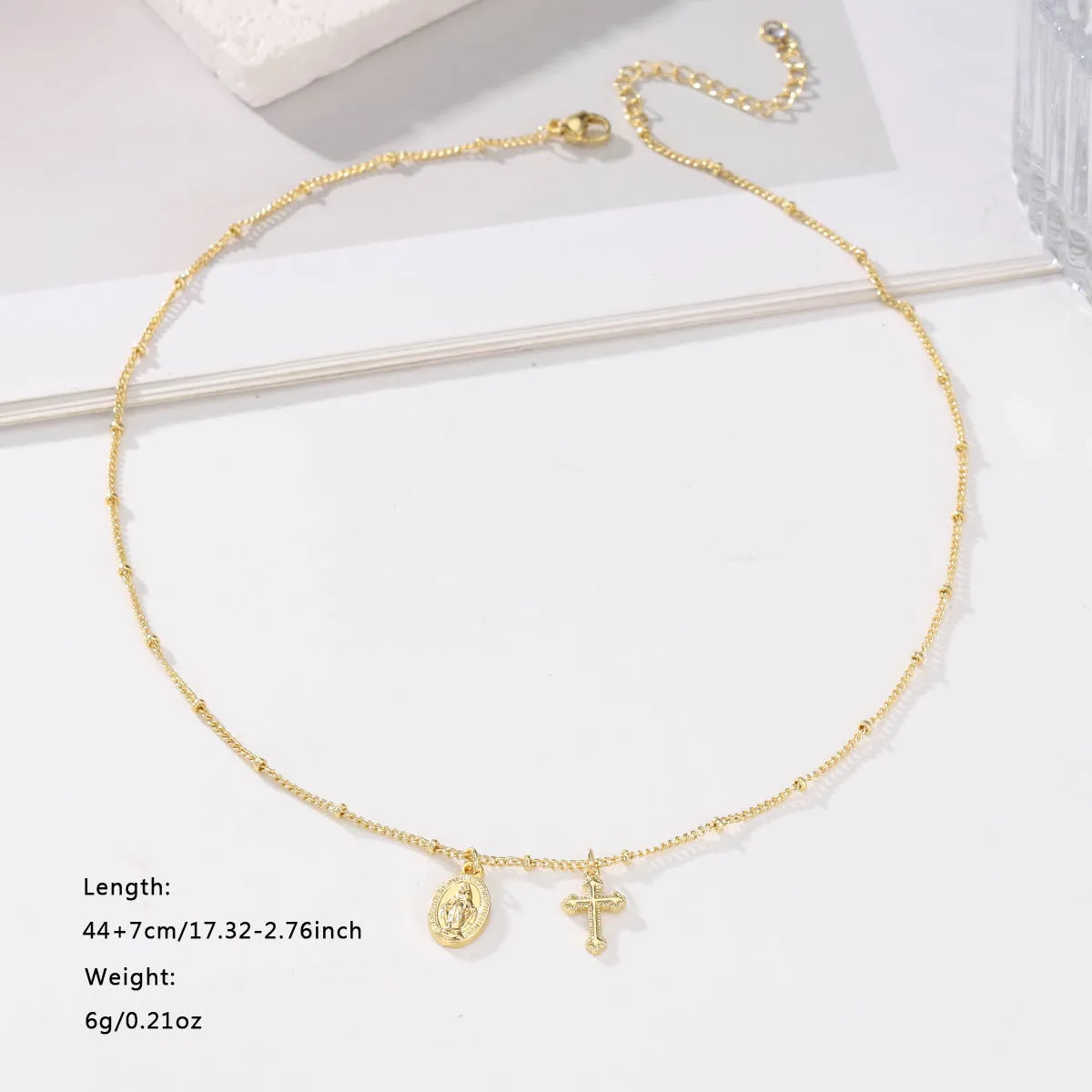 Geometric Virgin Mary cross pendant necklace in gold on a 45cm chain with lobster clasp.