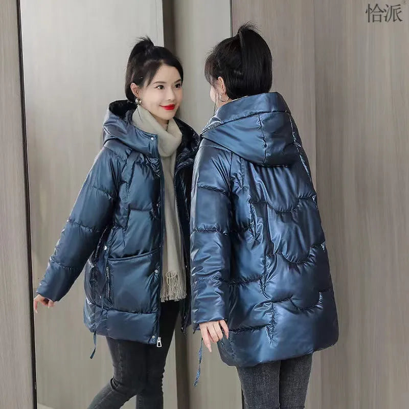 Women's loose-fit green hooded winter jacket with long sleeves on a hanger.