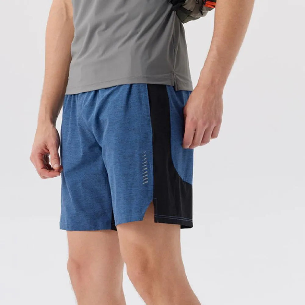 Man wearing mid-waist forest green spandex shorts, showcasing the casual fit and short length.