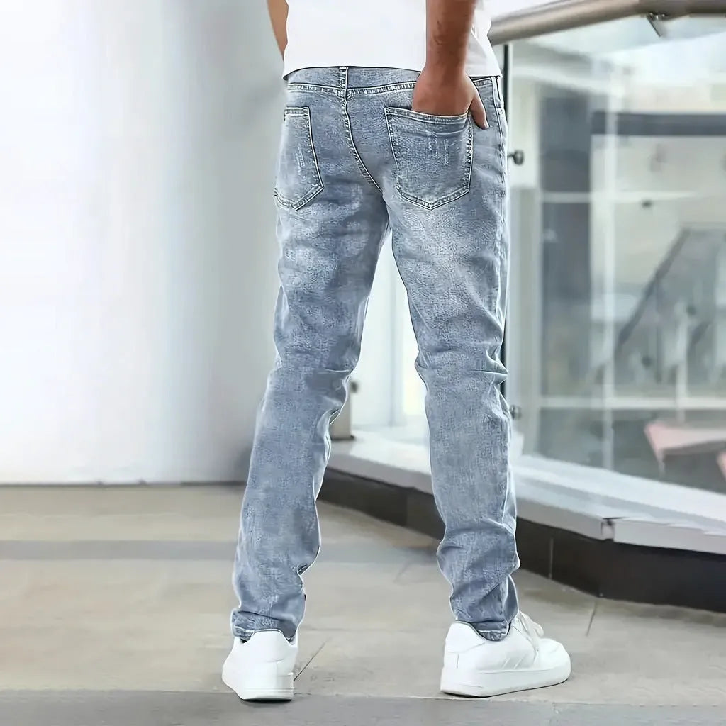 A pair of men's solid colour stretch jeans in a straight leg skinny fit, shown in dark blue.