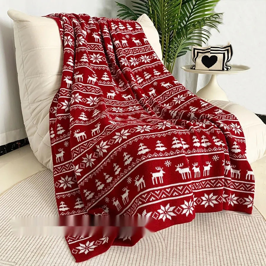 Personalised acrylic Christmas blanket with reindeer pattern draped over a grey sofa