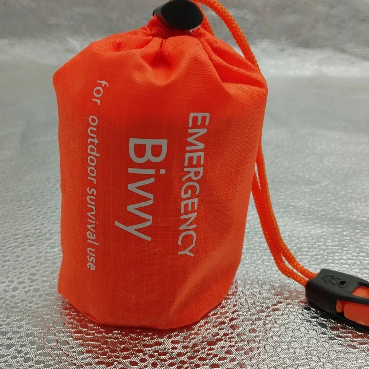 Aluminium film emergency sleeping bag in orange or green, 93x210cm, with drawstring bag and whistle.