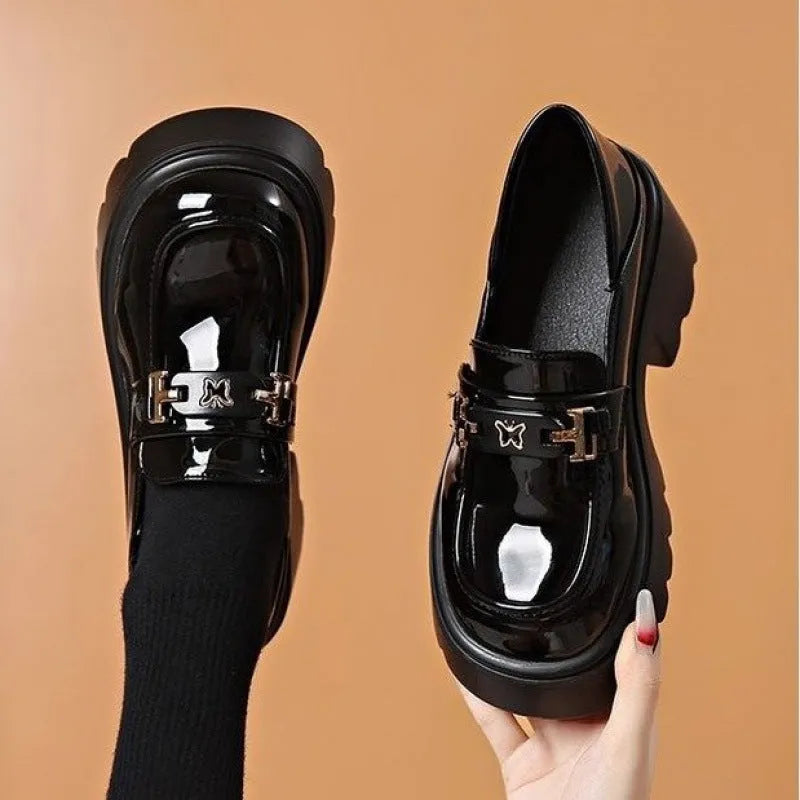Black leather slip-on shoes with chunky square heel, round toe, and skull pattern design.