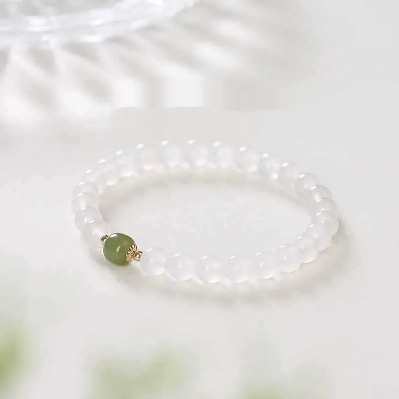 Handmade white agate and crystal bracelet with cinnabar inlay, showing text design on beads