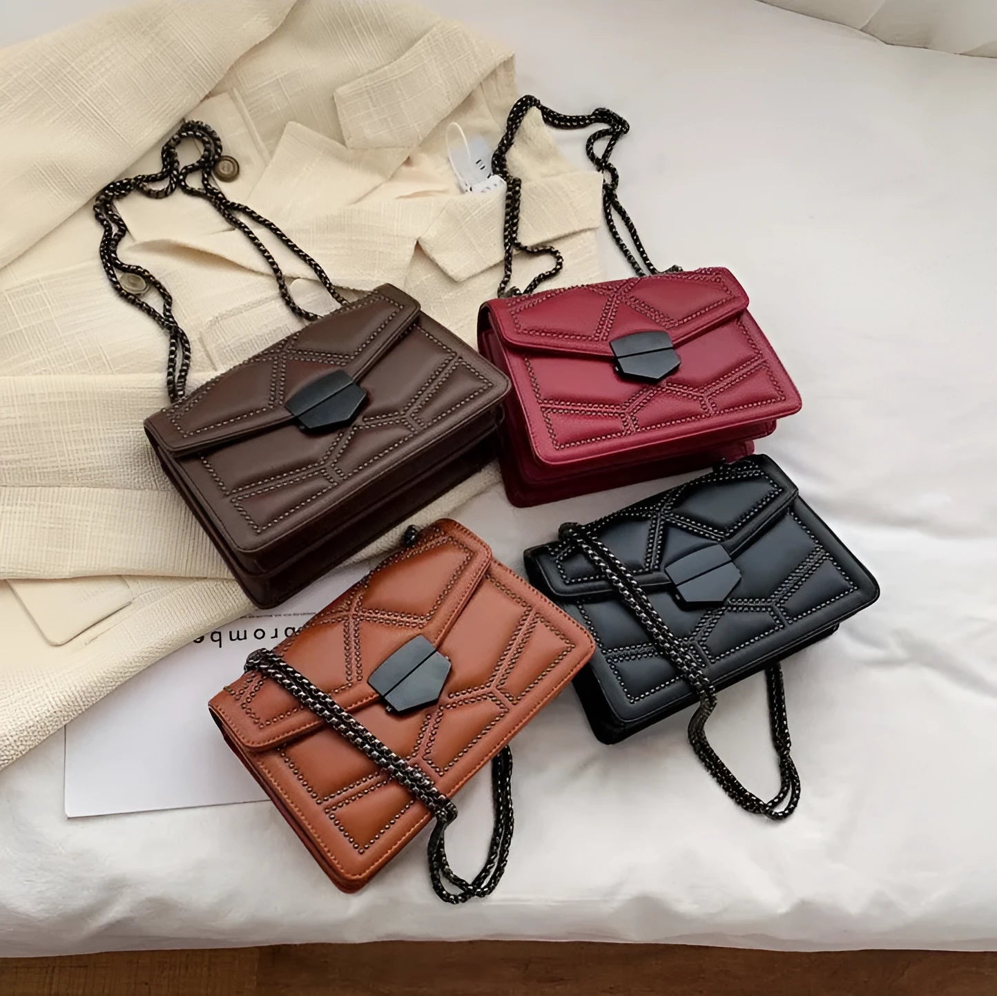 Small square shoulder bag with studs, chain handle, and zipper closure in wine red colour