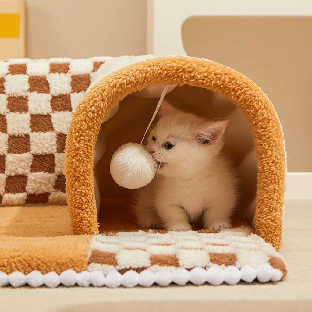 XL fan-shaped plush pet bed with a tunnel, in a plaid coffee colour, on a wooden floor.