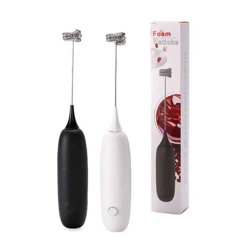 Handheld electric milk frother blender in black and white colour options on a kitchen counter.