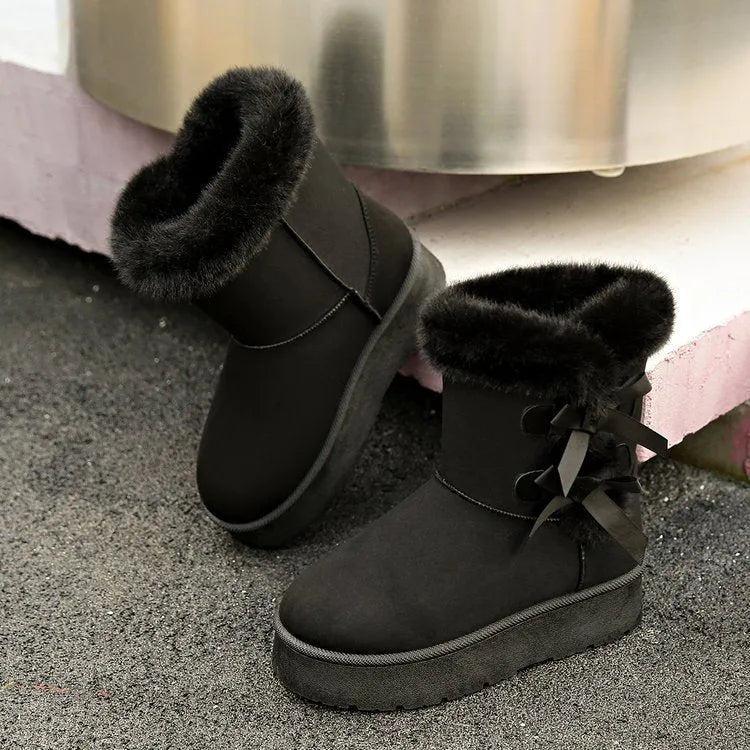 Women's suede ankle boots with fleece lining, flat heel, and bow detail in beige