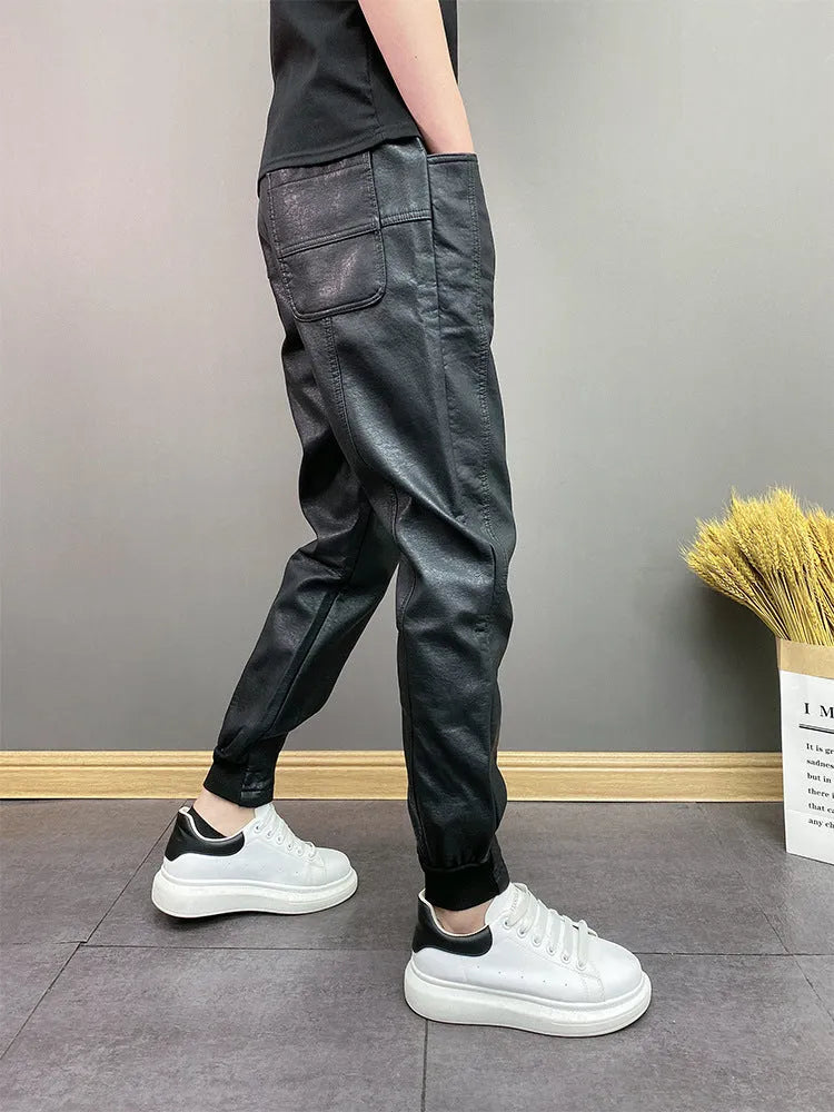 Black slim-fit waterproof motorcycle trousers in artificial leather with mid-rise waist and tapered leg