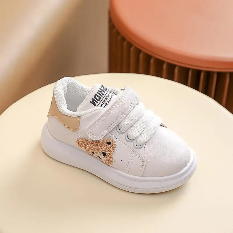 Children's black sports shoes with a cartoon bear design on the artificial leather upper and a rubber sole.