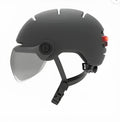 Cycling helmet with integrated red LED brake light on the back, shown in sizes M and L.