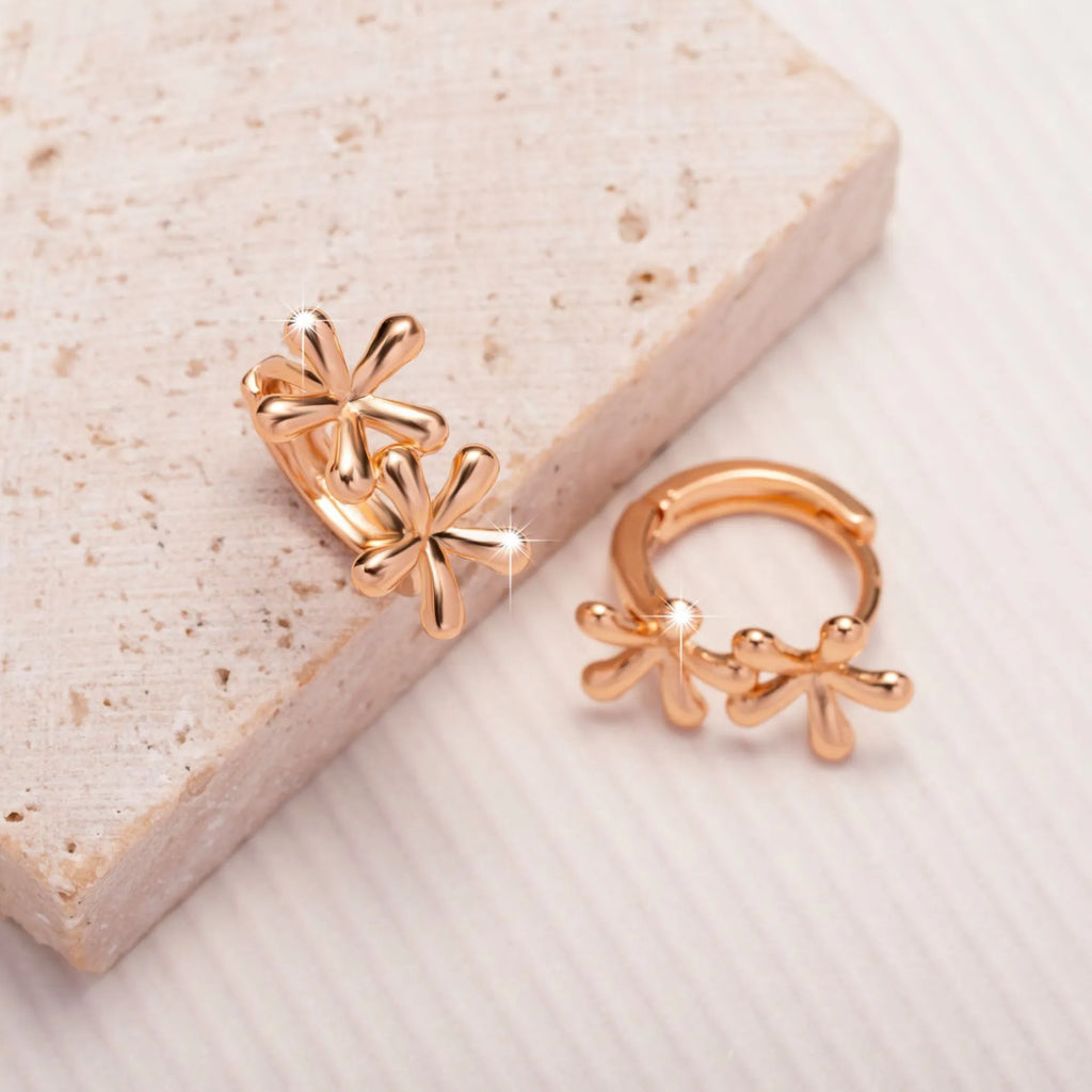 Rose gold electroplated earrings with a waterdrop shape and detailed floral petal etching on a white background.