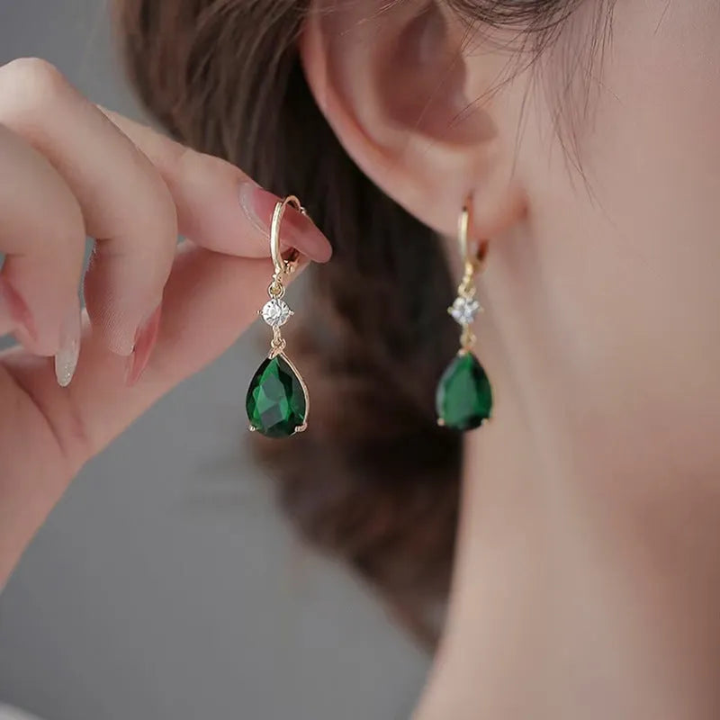 A pair of geometric teardrop-shaped earrings in emerald green colour.