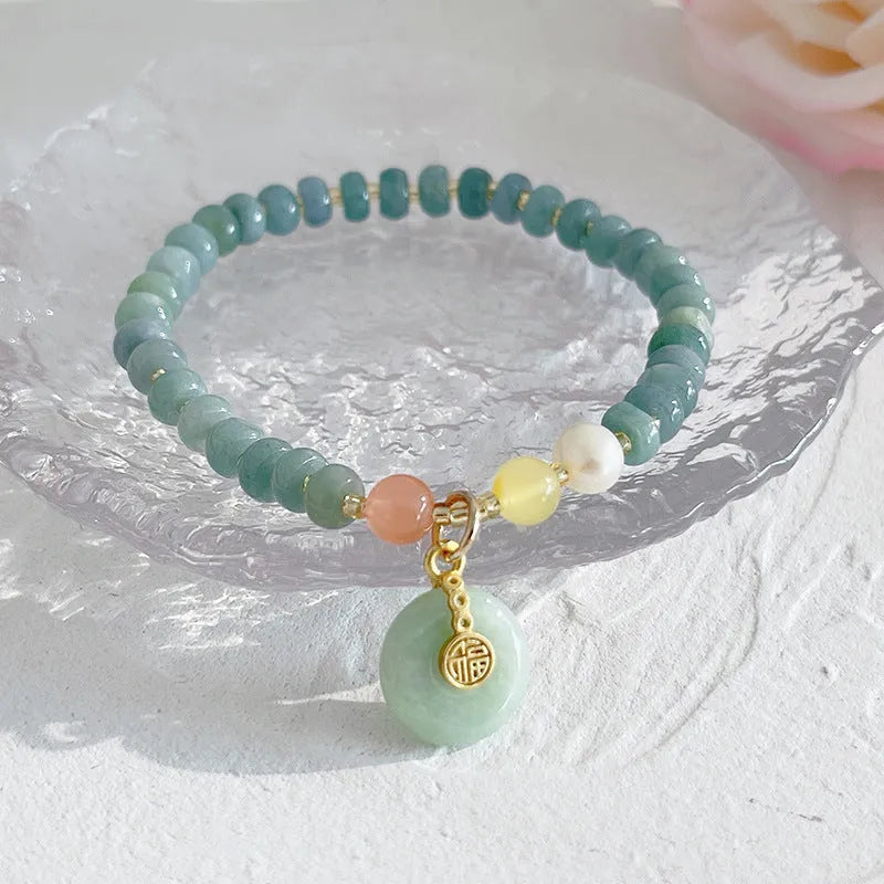Women's simple jade bracelet with blue gourd charm and silver peace buckle on a beaded strand.