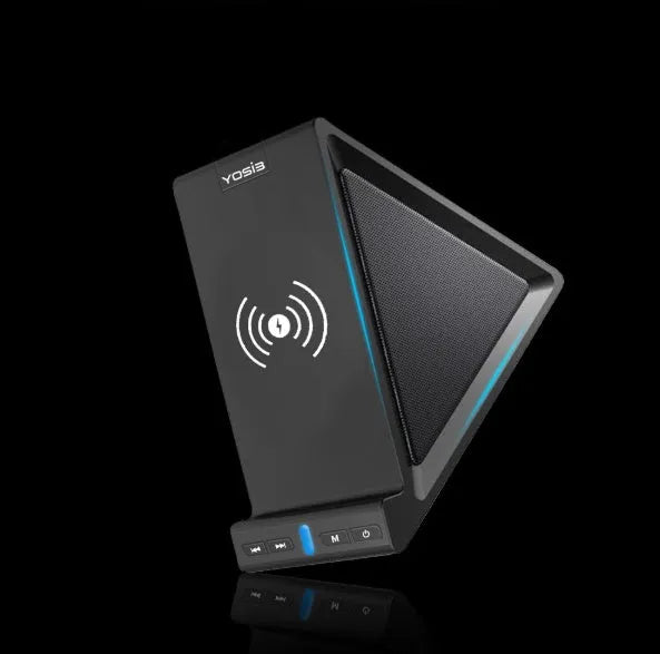 Black multifunctional Bluetooth speaker with integrated phone stand and wireless charging pad on a desk.
