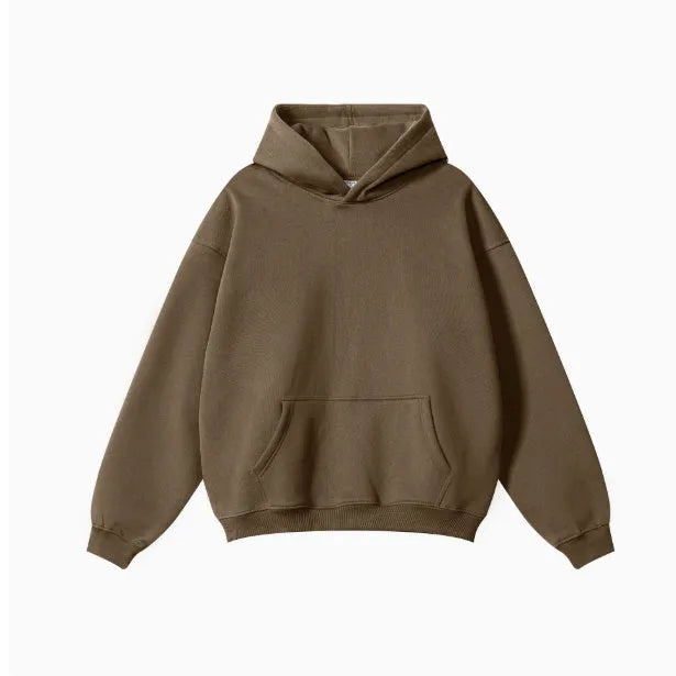 A man wearing a loose-fit, hooded terry cotton sweatshirt in a caramel colour.