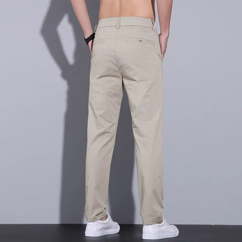 Men's straight-leg light khaki cotton trousers with a slim fit, laid flat to show the cut and micro-elastic fabric.