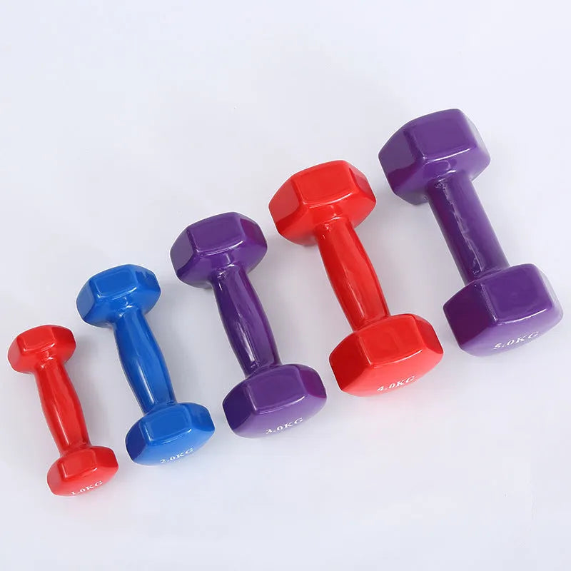Set of bright coloured plastic fitness dumbbells showing 0.5kg, 1kg, and 1.5kg weights on a floor.