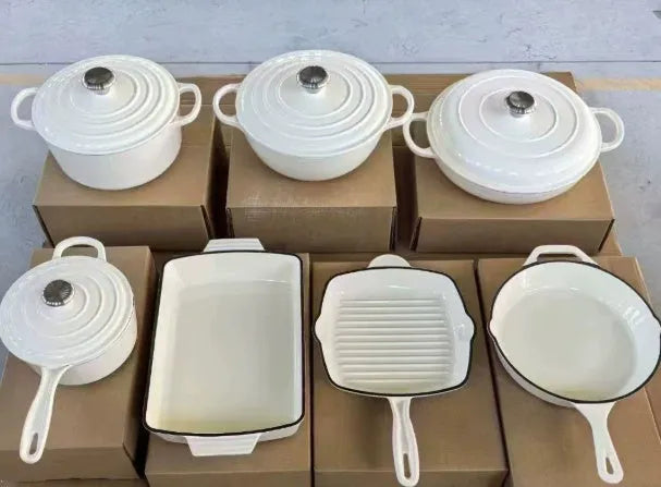 Cast iron enamel casserole set with frying pan and stew pot in light blue colour on a wooden table