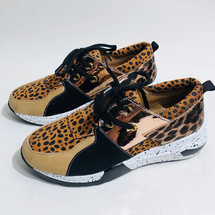 Women's suede sneakers with a wedge heel in leopard print, shown on a foot.