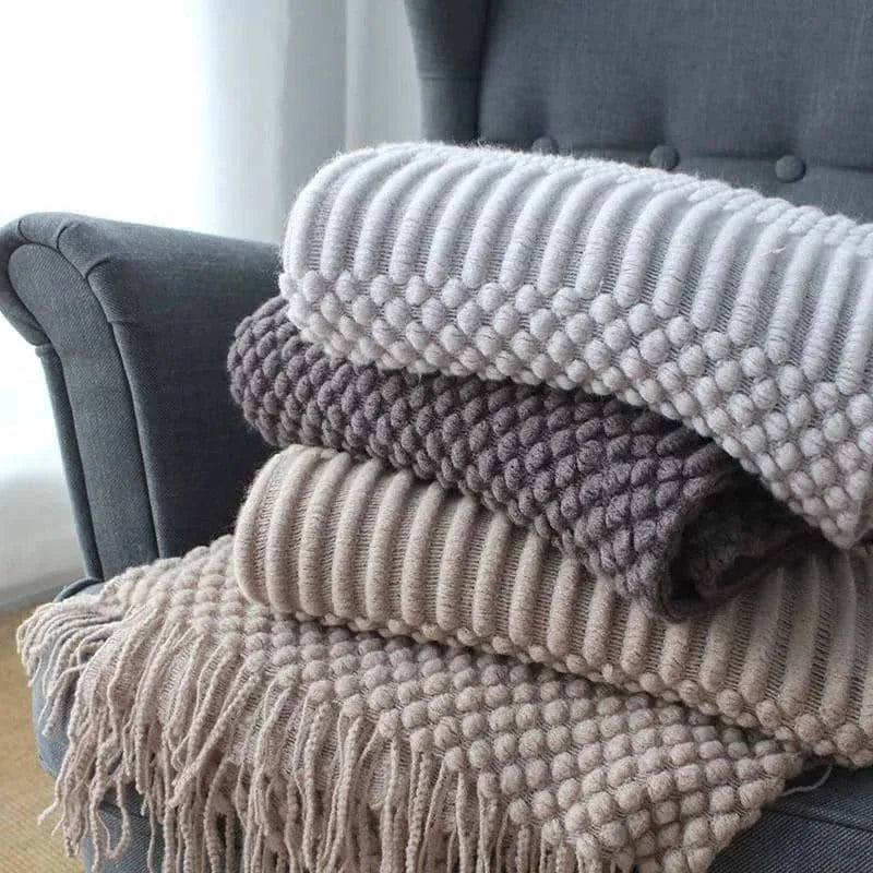 Small grey polyester nap blanket folded, showing its 127x170cm size on a sofa.