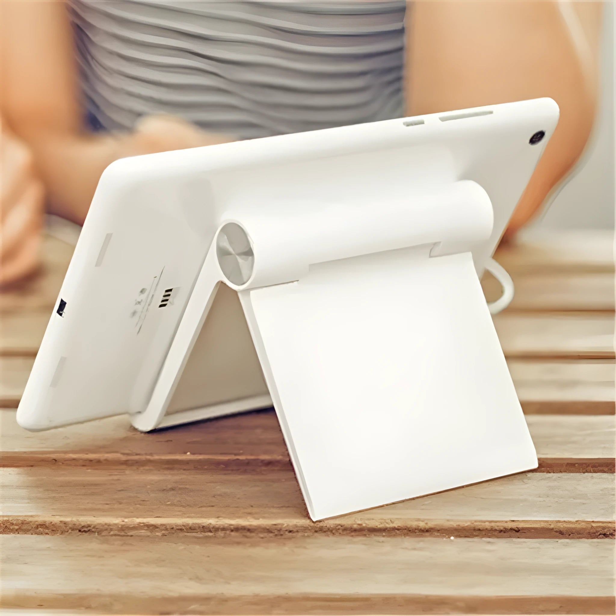 Folding plastic desktop stand holding a smartphone in black colour on a desk