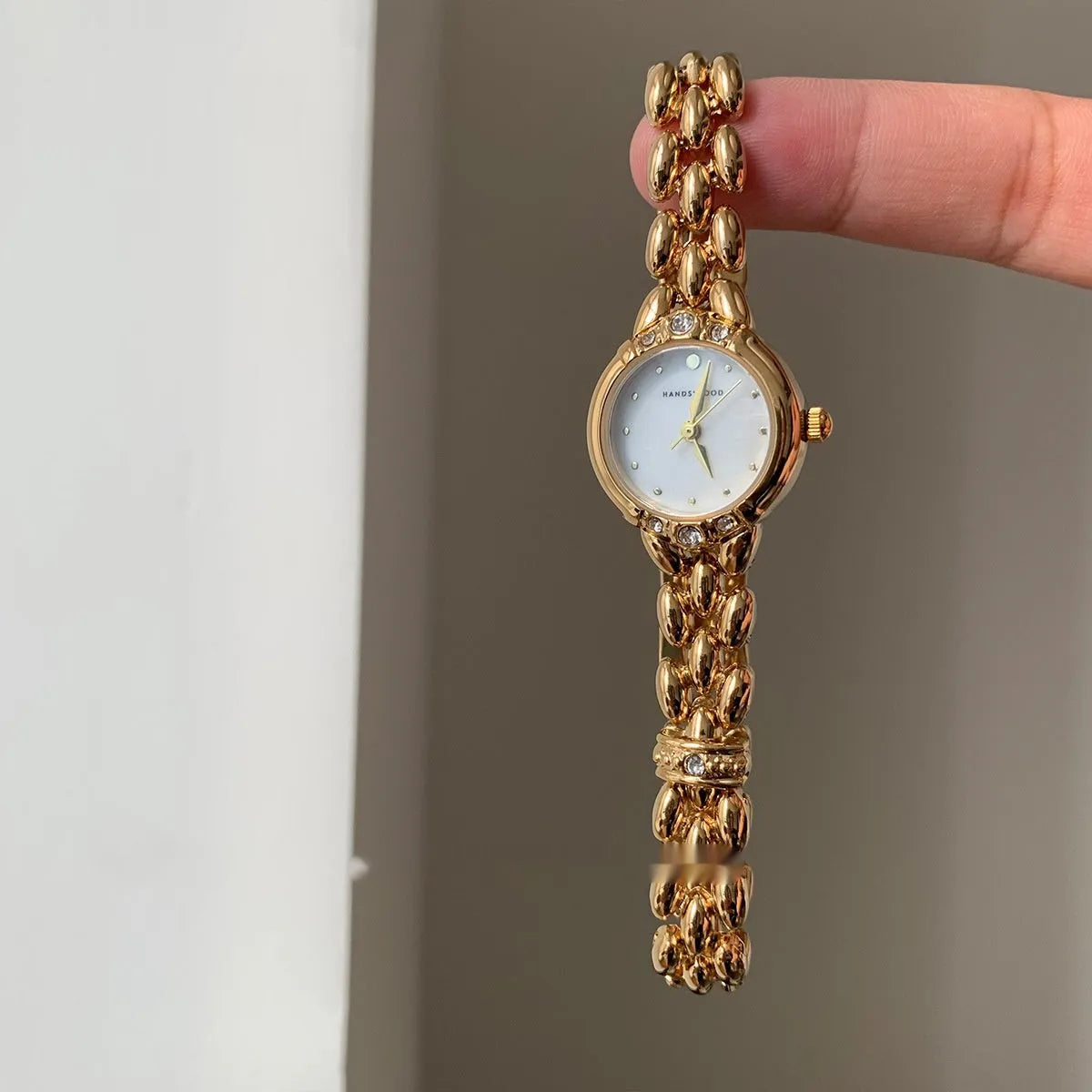 Women's gold strap alloy quartz watch with fritillary surface dial and rhinestone accents