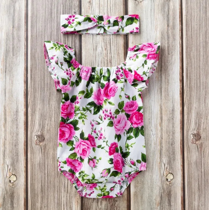 Baby girl in a black cotton romper with small flying sleeves print, showing sleeveless triangle climbing style.